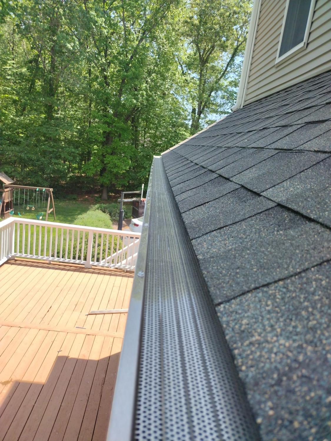 Clean gutter with guard above a wooden deck